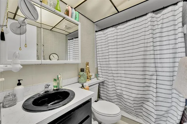 a bathroom with a sink a toilet and shower curtain