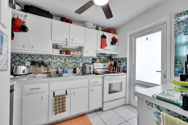 a kitchen with white cabinets and white appliances