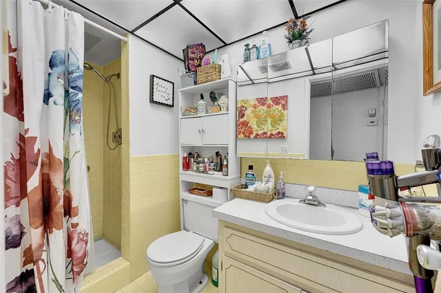 a bathroom with a sink a toilet and shower curtain