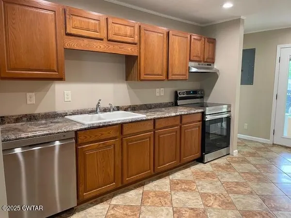 a kitchen with stainless steel appliances granite countertop a stove top oven a sink dishwasher a refrigerator and a microwave oven with wooden floor