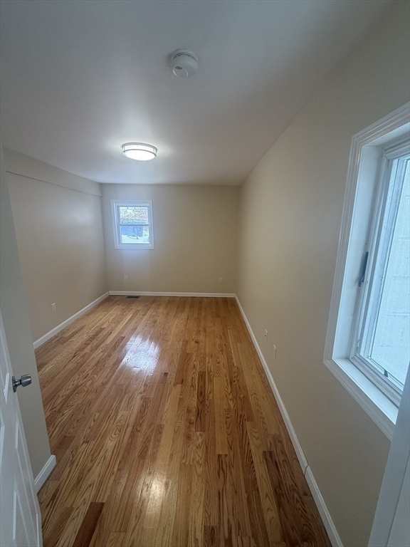 7 Williston Road, Unit A Belmont, MA 02478 - Photo 2 of 10 a view of empty room with wooden floor and fan