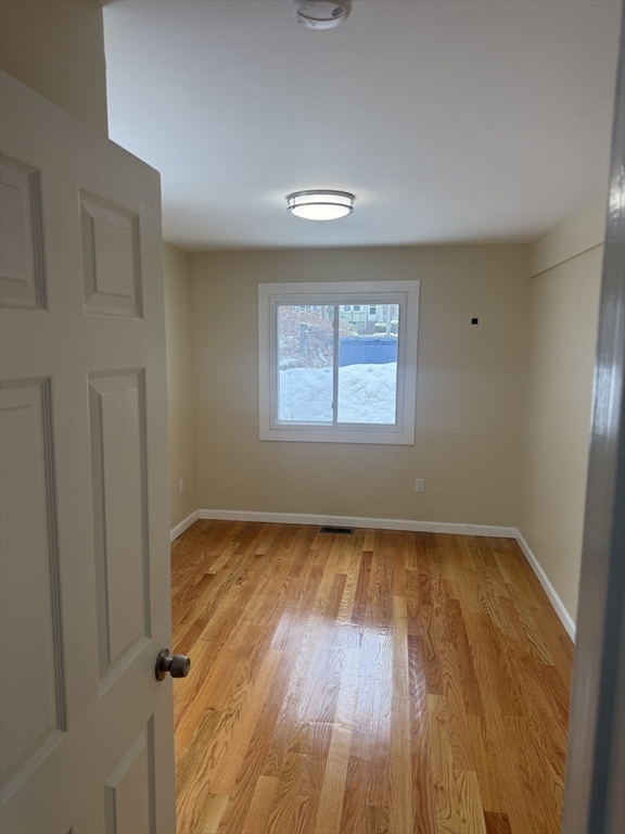 7 Williston Road, Unit A Belmont, MA 02478 - Photo 8 of 10 wooden floor in an empty room with a window