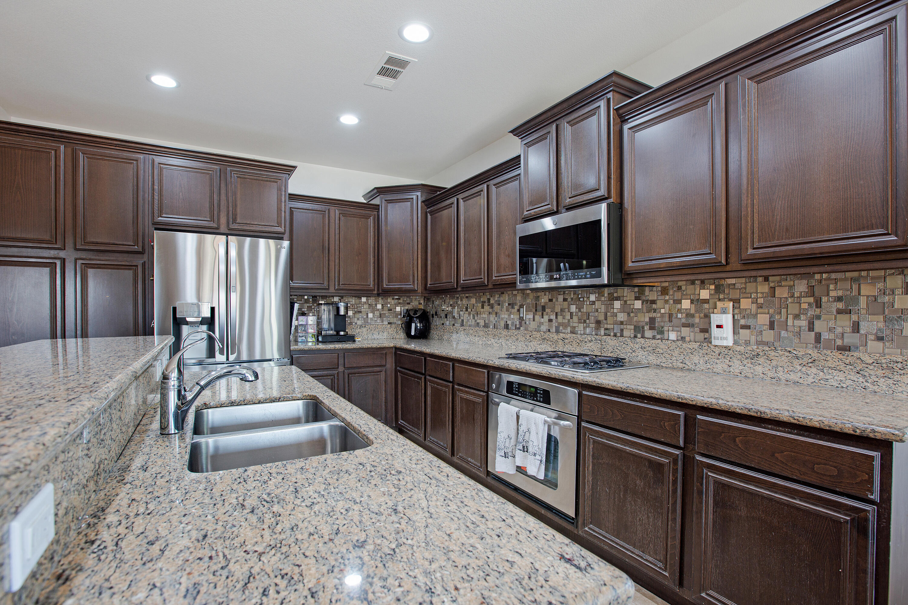 35922 Raphael Drive Palm Desert, CA 92211 - Photo 13 of 33 a kitchen with kitchen island granite countertop wooden cabinets a sink and a stove