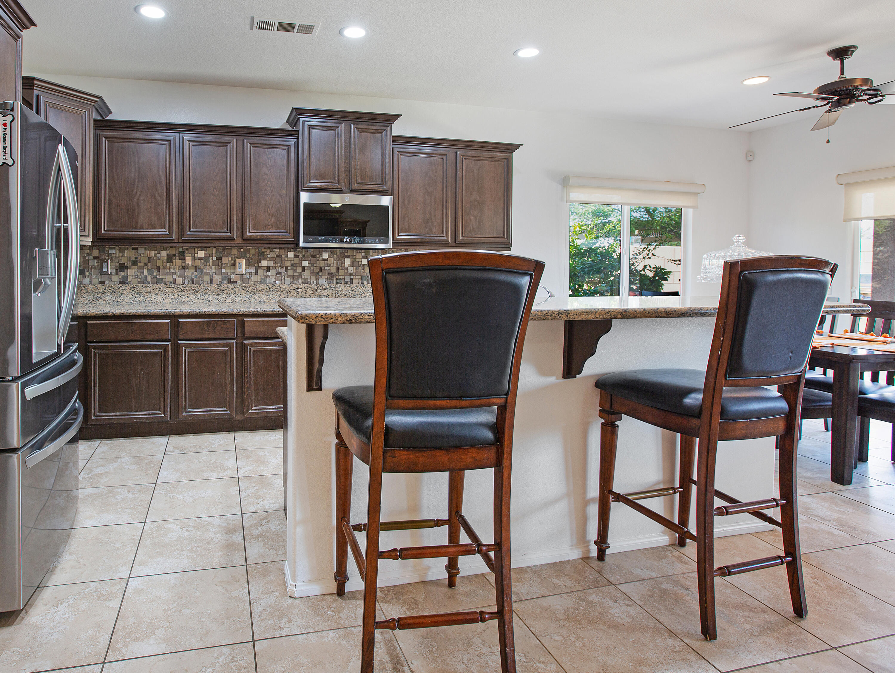 35922 Raphael Drive Palm Desert, CA 92211 - Photo 14 of 33 a kitchen with granite countertop a table chairs microwave and refrigerator