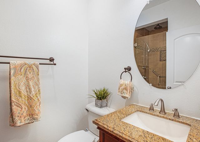 a bathroom with a granite countertop sink and a mirror