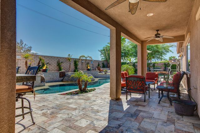 a view of a patio with table and chairs potted plants with floor to ceiling window