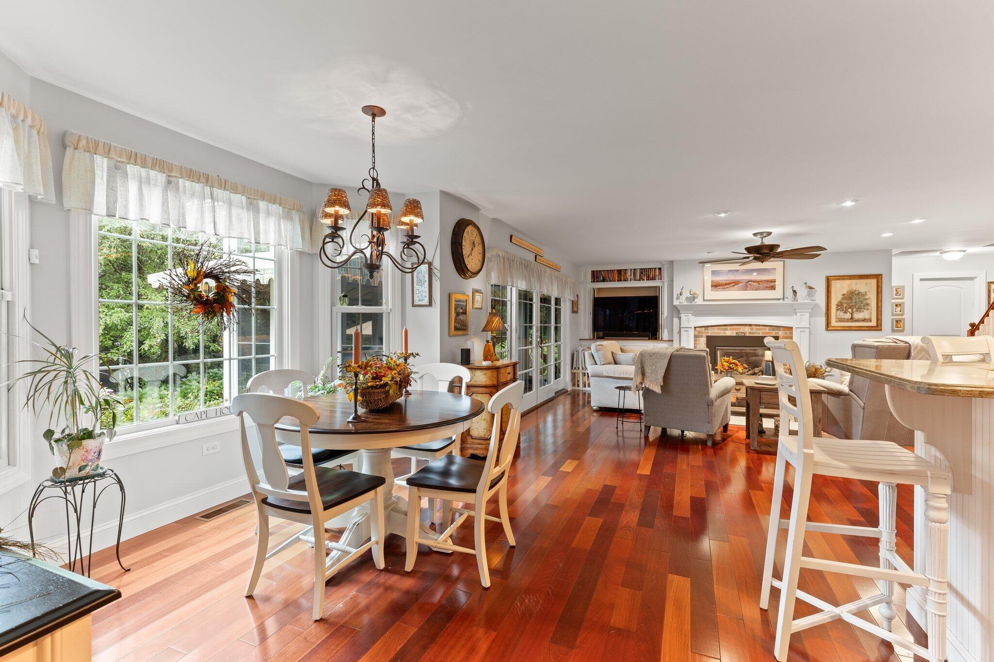 9 Briar Spring Road Orleans, MA 02653 - Photo 25 of 65 a dining room with wooden floor a chandelier a glass table and chairs