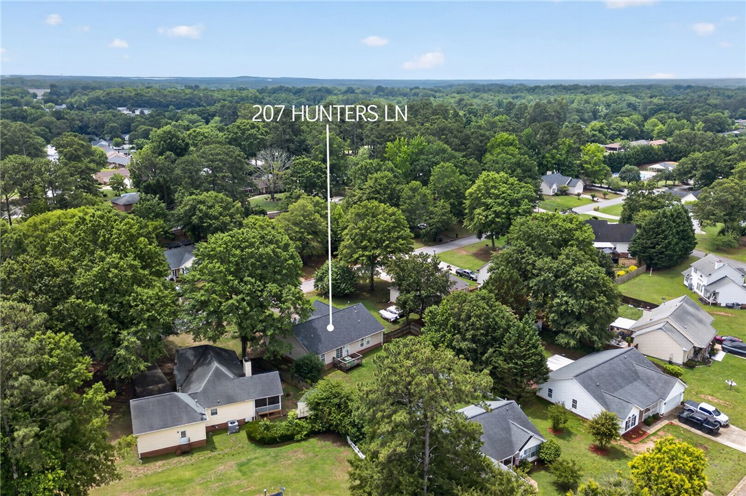 207 Hunters Lane Anderson, SC 29625 - Photo 42 of 46 An aerial perspective showcases a residential neighborhood nestled amidst lush, mature trees.