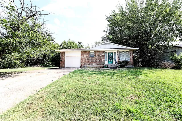 a view of a house with a yard and sitting area