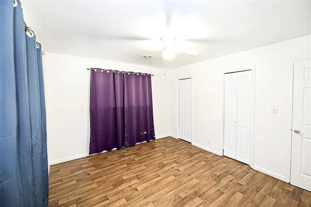 a view of a bedroom with wooden floor and closet