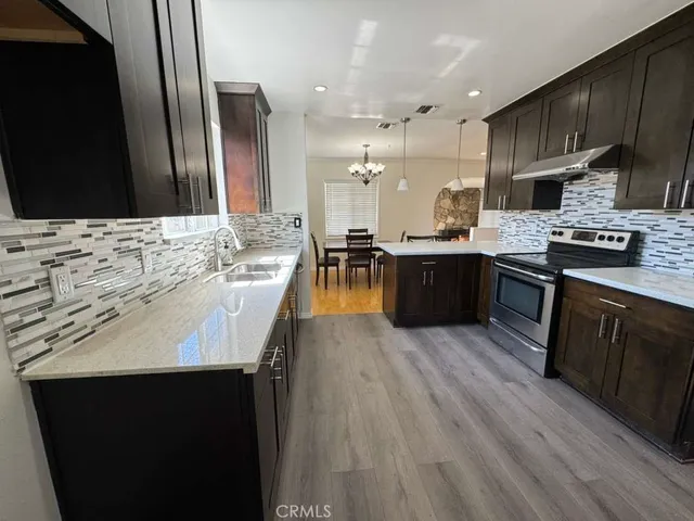 a large kitchen with stainless steel appliances kitchen island granite countertop a stove and a sink