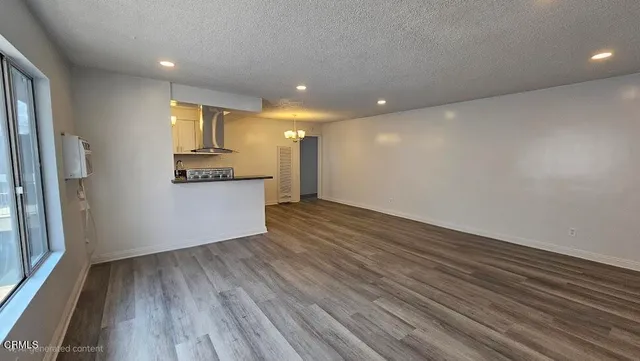 a view of a kitchen with wooden floor and a refrigerator