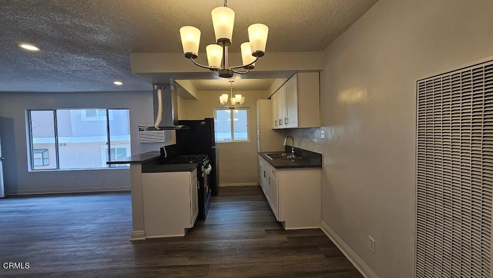 1710 Vine Street, Unit H Alhambra, CA 91801 - Photo 6 of 13 a kitchen with a refrigerator chandelier stainless steel appliances and wooden floor