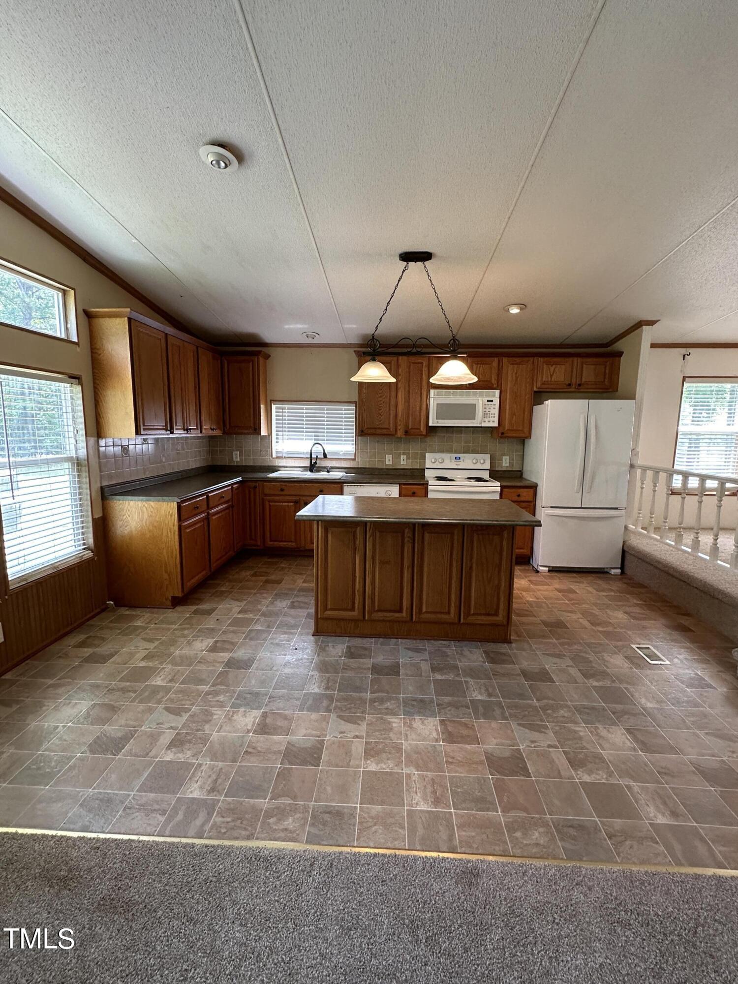 291 Pixley Pritchard Road Timberlake, NC 27583 - Photo 8 of 38 a large kitchen with stainless steel appliances granite countertop a stove granite counter tops a stove a dining table and chairs