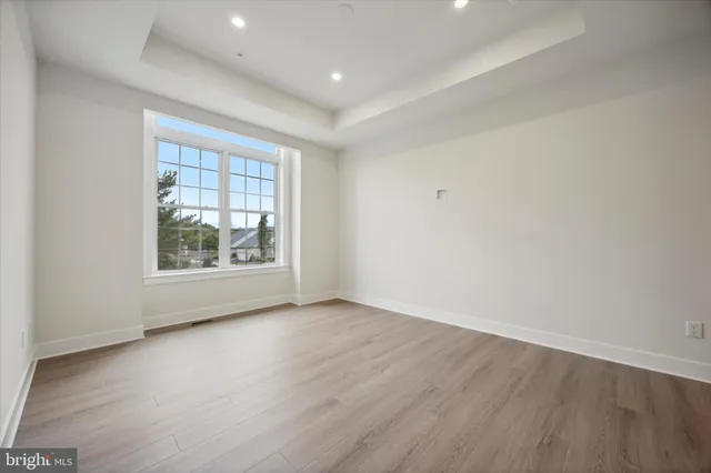 an empty room with wooden floor and window