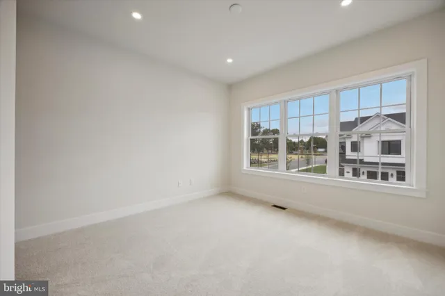 an empty room with wooden floor and natural light