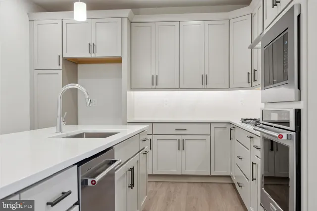 a kitchen with cabinets appliances and a sink