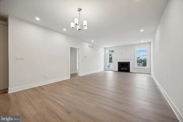 a view of empty room with wooden floor and fireplace