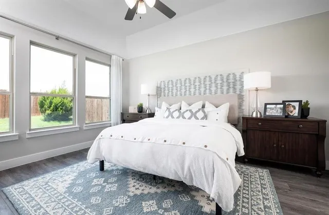a large bed sitting in a bedroom next to a window