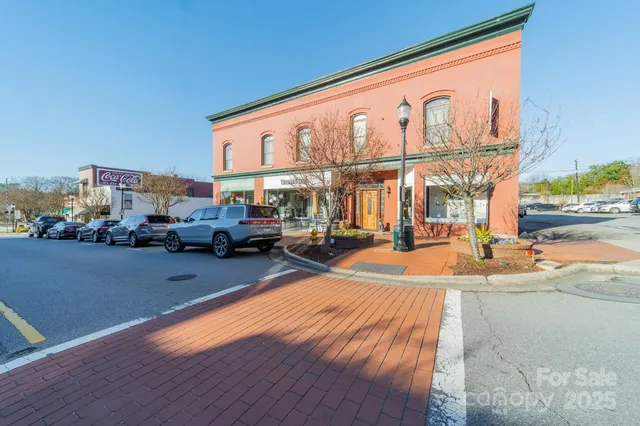 a front view of a building with large trees