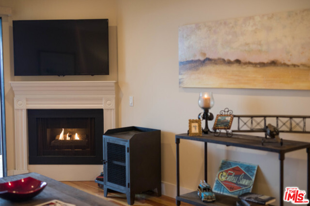 26664 Seagull Way, Unit A105 Malibu, CA 90265 - Photo 5 of 23 a living room with furniture and a fireplace