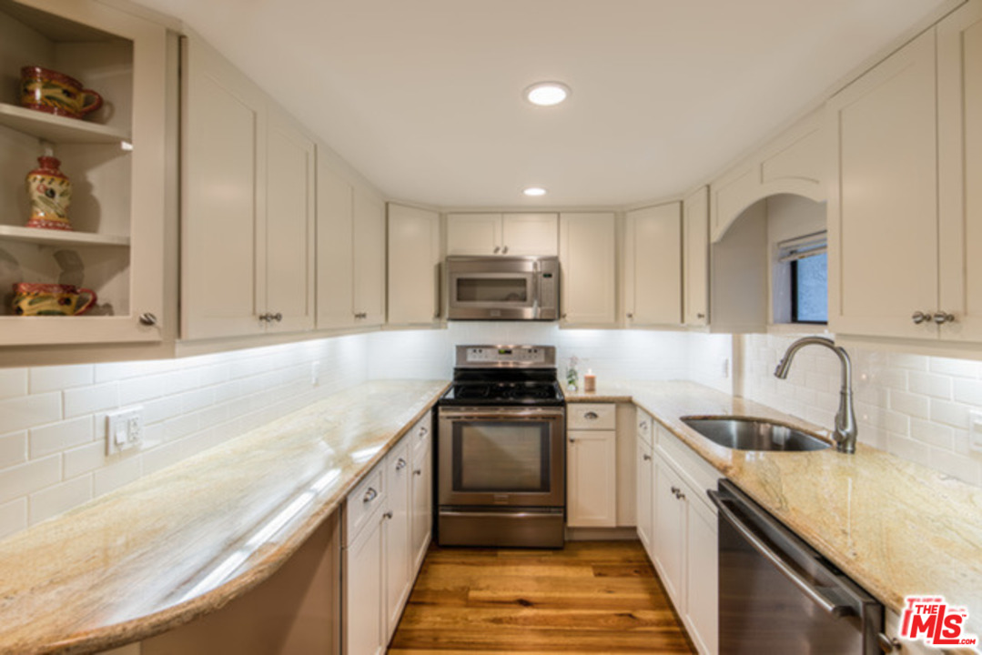 26664 Seagull Way, Unit A105 Malibu, CA 90265 - Photo 7 of 23 a kitchen with a sink stove top oven and refrigerator