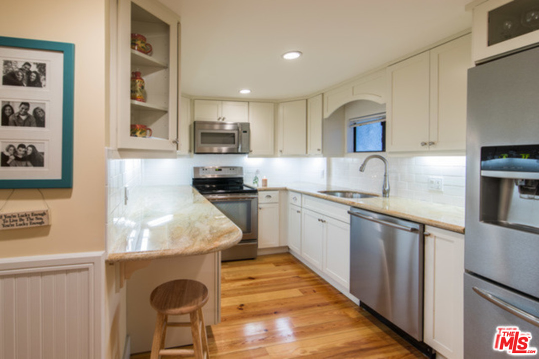 26664 Seagull Way, Unit A105 Malibu, CA 90265 - Photo 8 of 23 a kitchen with stainless steel appliances granite countertop a sink a stove and a refrigerator
