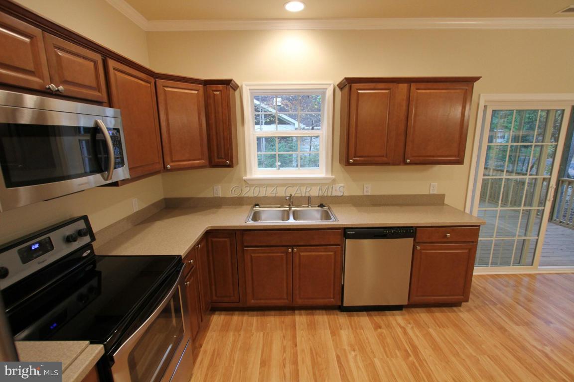 40 Capetown Road Ocean Pines, MD 21811 - Photo 8 of 23 a kitchen with stainless steel appliances granite countertop a stove a sink and a microwave