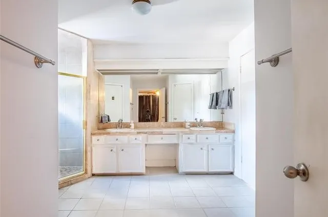 a large white bathroom with a sink a mirror and a bathtub