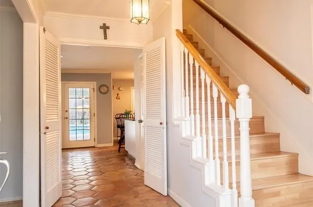 a view of a hallway with wooden floor and staircase