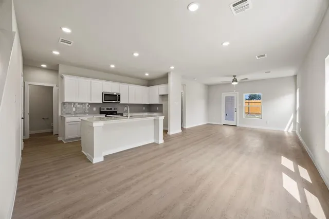 a view of kitchen with cabinets microwave and stove