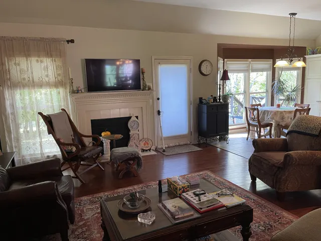 a living room with furniture a flat screen tv and a fireplace