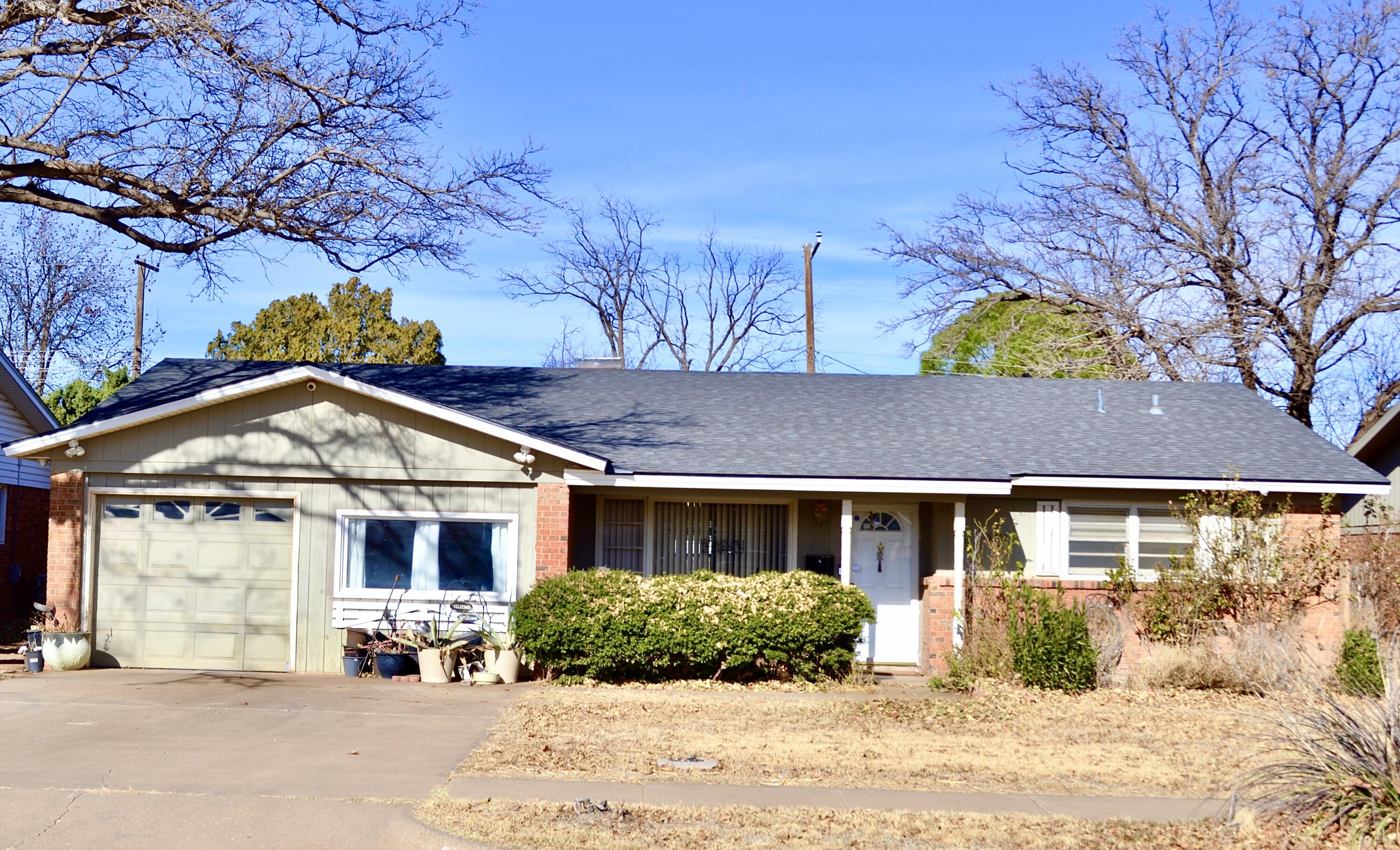 a front view of a house with a yard and potted plants