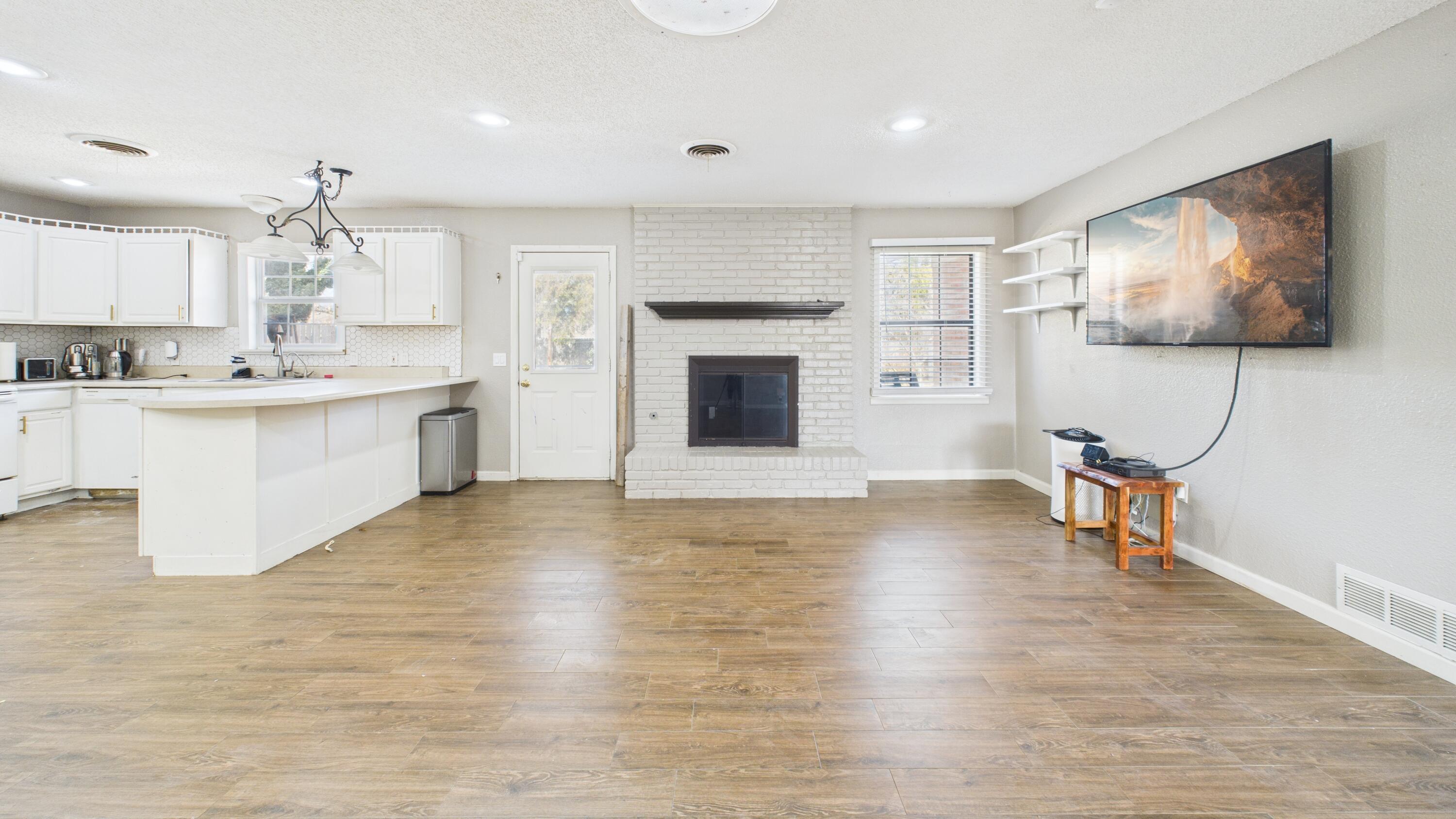 5410 41st Street Lubbock, TX 79414 - Photo 22 of 40 a living room with granite countertop furniture a fireplace and a flat screen tv