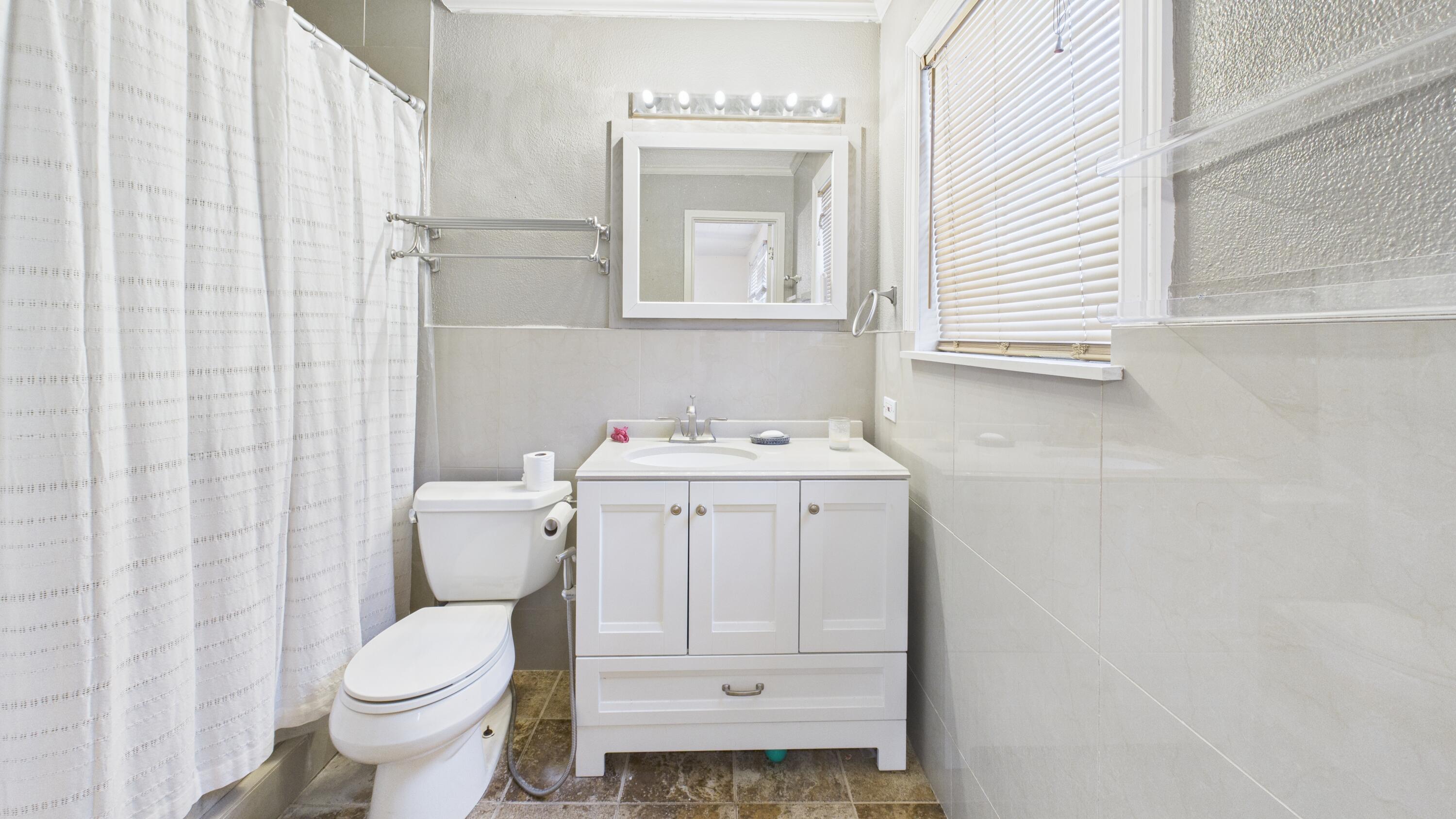 5410 41st Street Lubbock, TX 79414 - Photo 30 of 40 a bathroom with a toilet sink and mirror