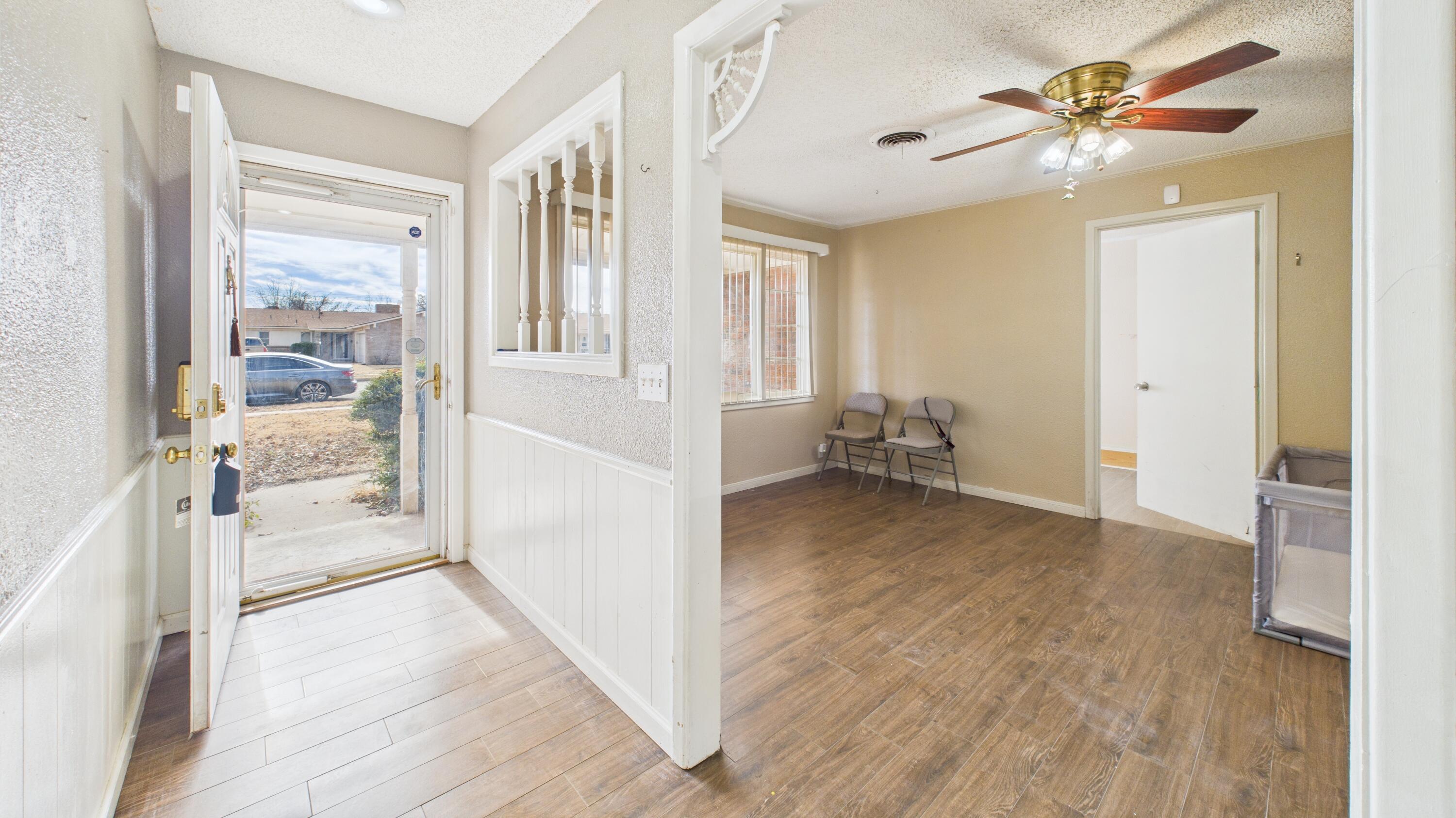 5410 41st Street Lubbock, TX 79414 - Photo 10 of 40 a view of a big room with wooden floor a chandelier fan and windows
