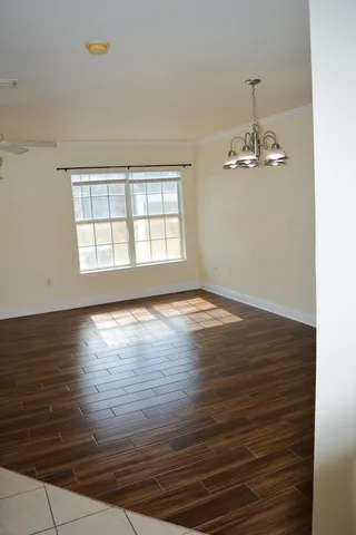 a view of a kitchen with wooden floor and cabinets