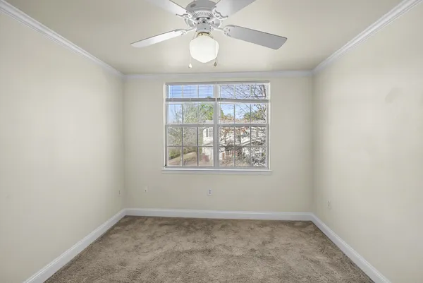 an empty room with a chandelier fan and closet