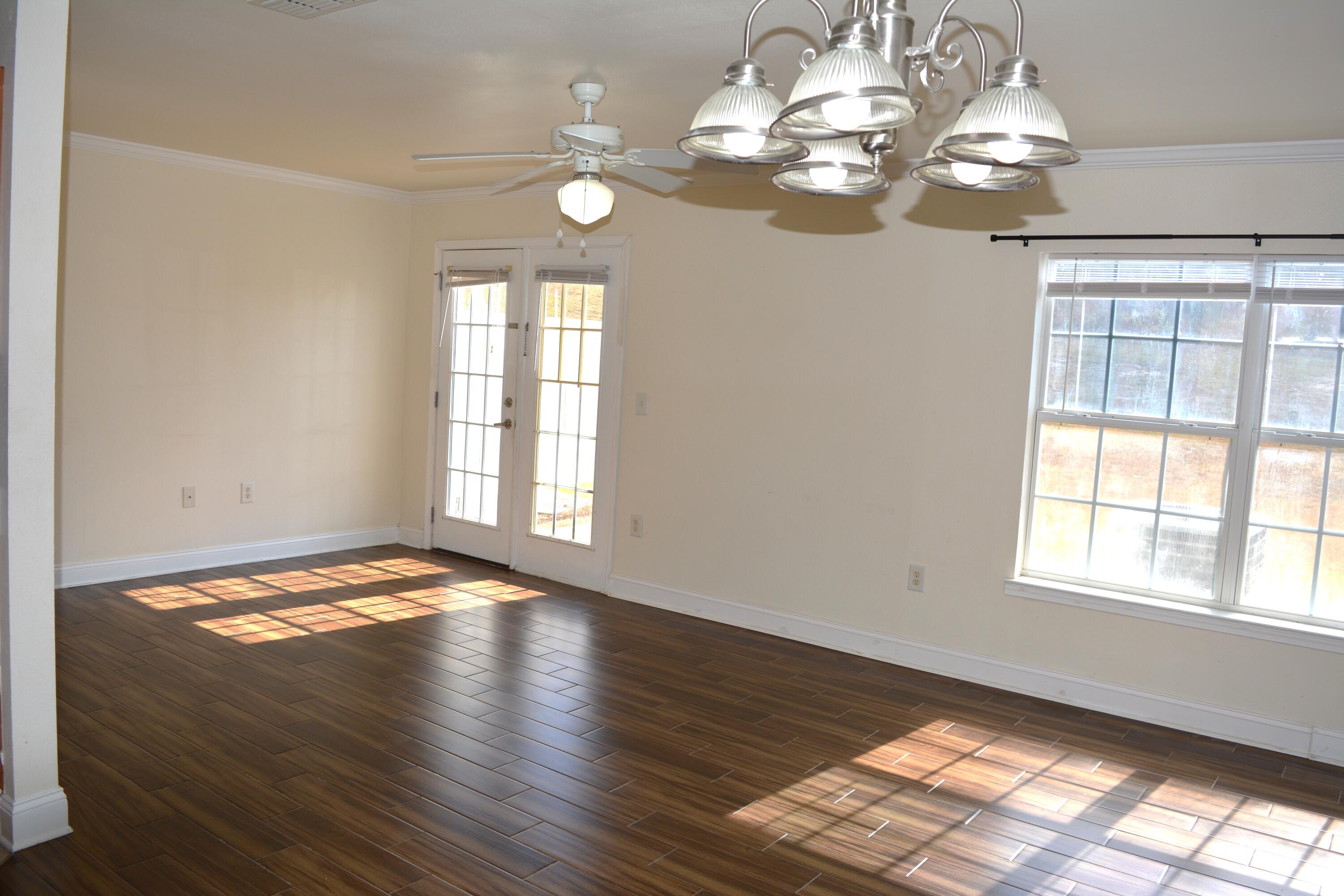 506 Wingspan Way Crestview, FL 32536 - Photo 22 of 38 a view of an empty room with wooden floor and a window