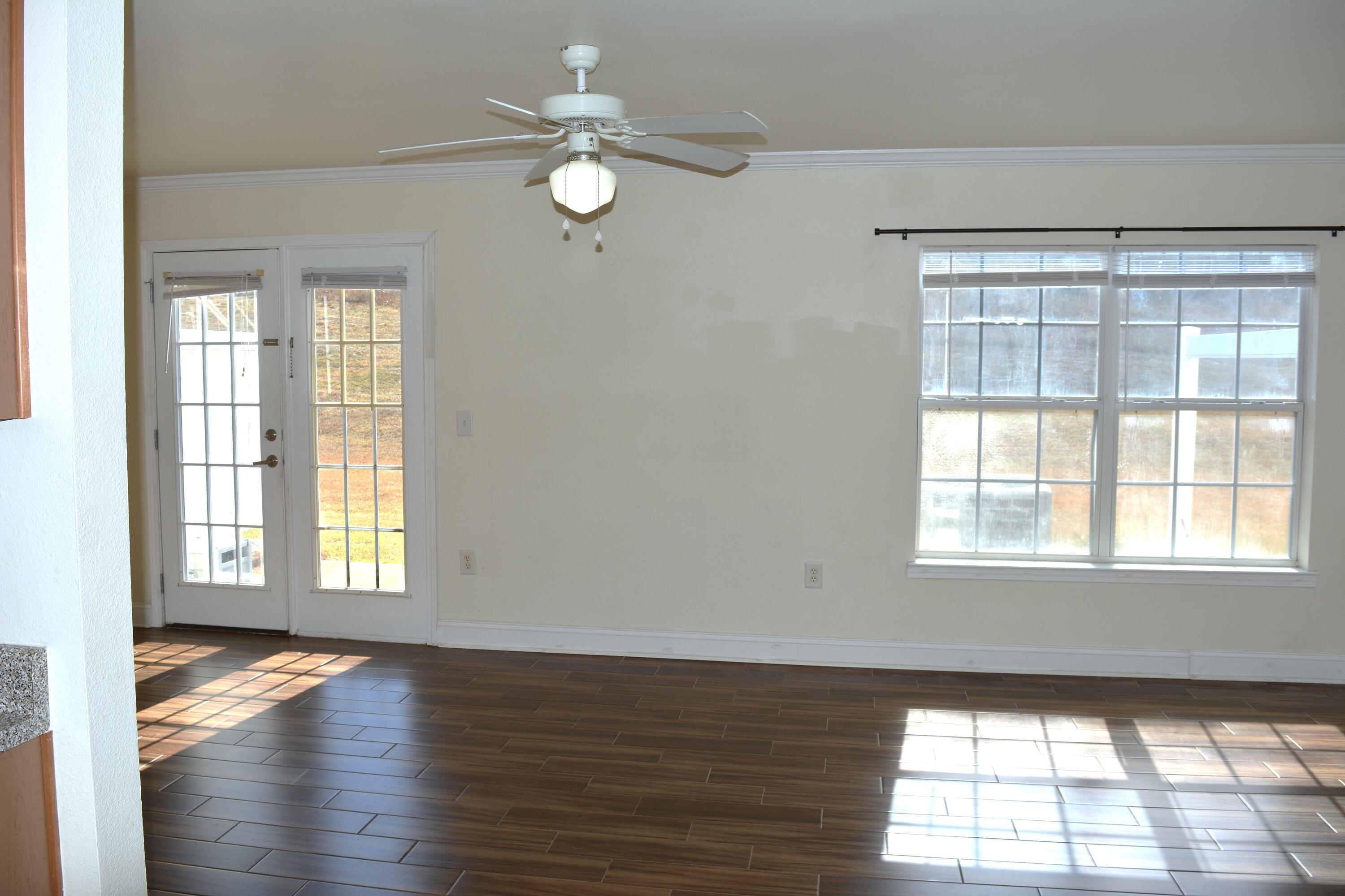 506 Wingspan Way Crestview, FL 32536 - Photo 23 of 38 an empty room with wooden floor and windows