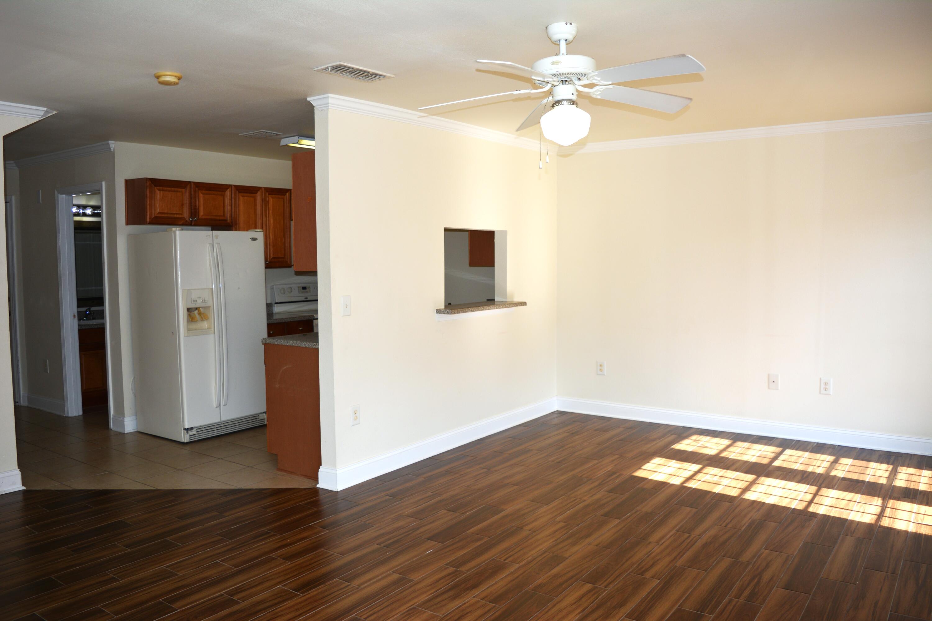 506 Wingspan Way Crestview, FL 32536 - Photo 24 of 38 a view of an empty room with wooden floor and a ceiling fan