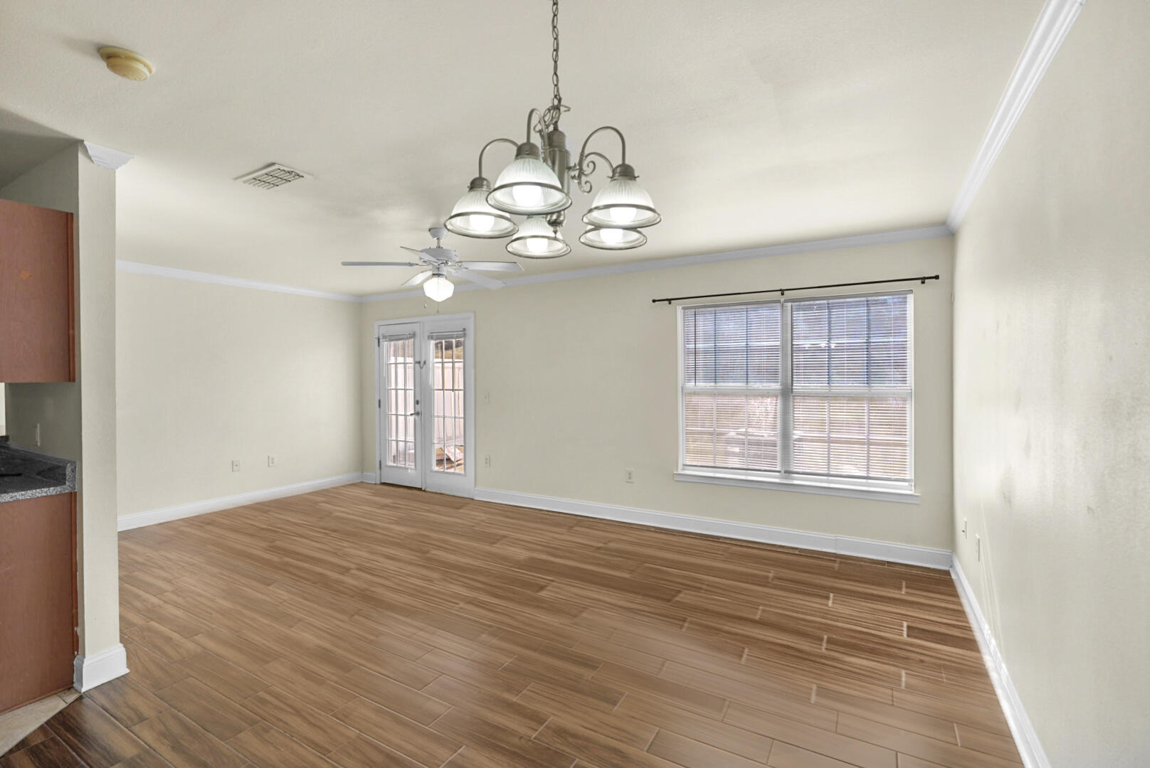 506 Wingspan Way Crestview, FL 32536 - Photo 5 of 33 a view of an empty room with wooden floor and a window
