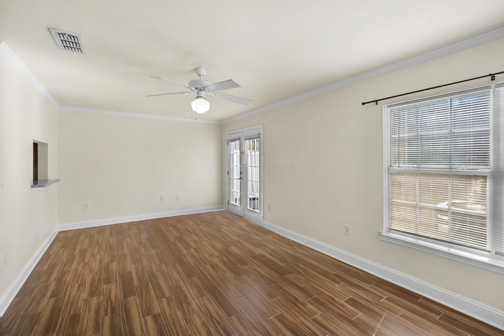 506 Wingspan Way Crestview, FL 32536 - Photo 6 of 33 a view of an empty room with wooden floor and a window