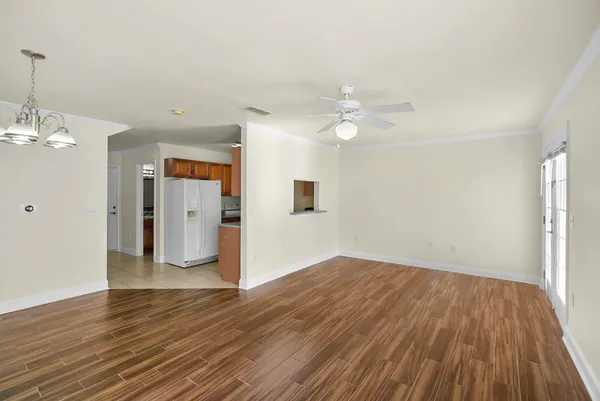 a view of empty room with wooden floor and ceiling fan