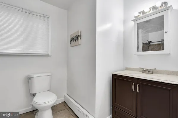 a bathroom with a toilet a sink and mirror