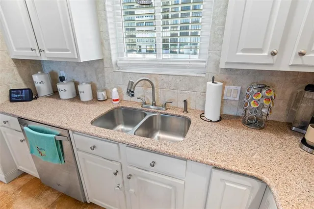 a kitchen with granite countertop a sink a stove and cabinets