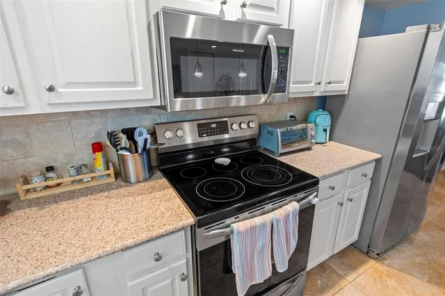 a kitchen with granite countertop a stove sink and cabinets