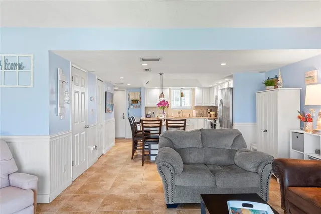 a living room with furniture and a dining table with kitchen view