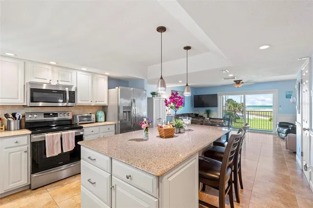 a kitchen with a dining table chairs stainless steel appliances and cabinets