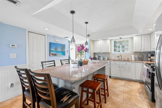 a view of a dining room and livingroom with furniture wooden floor a chandelier